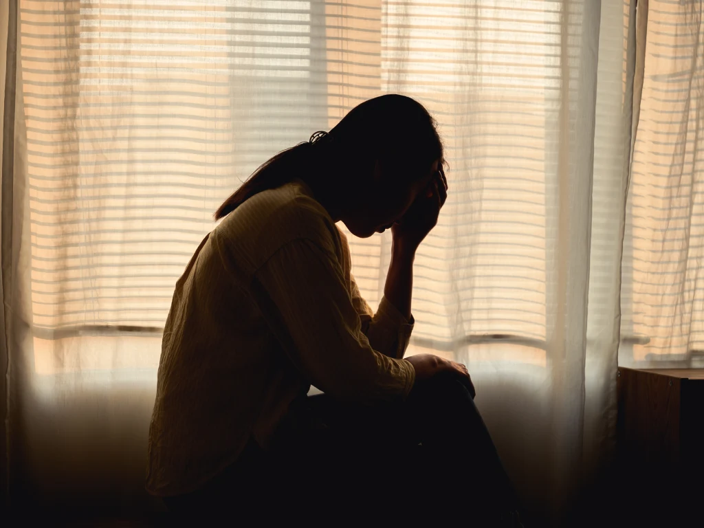 Person sitting alone showing symptoms of chronic stress and burnout.